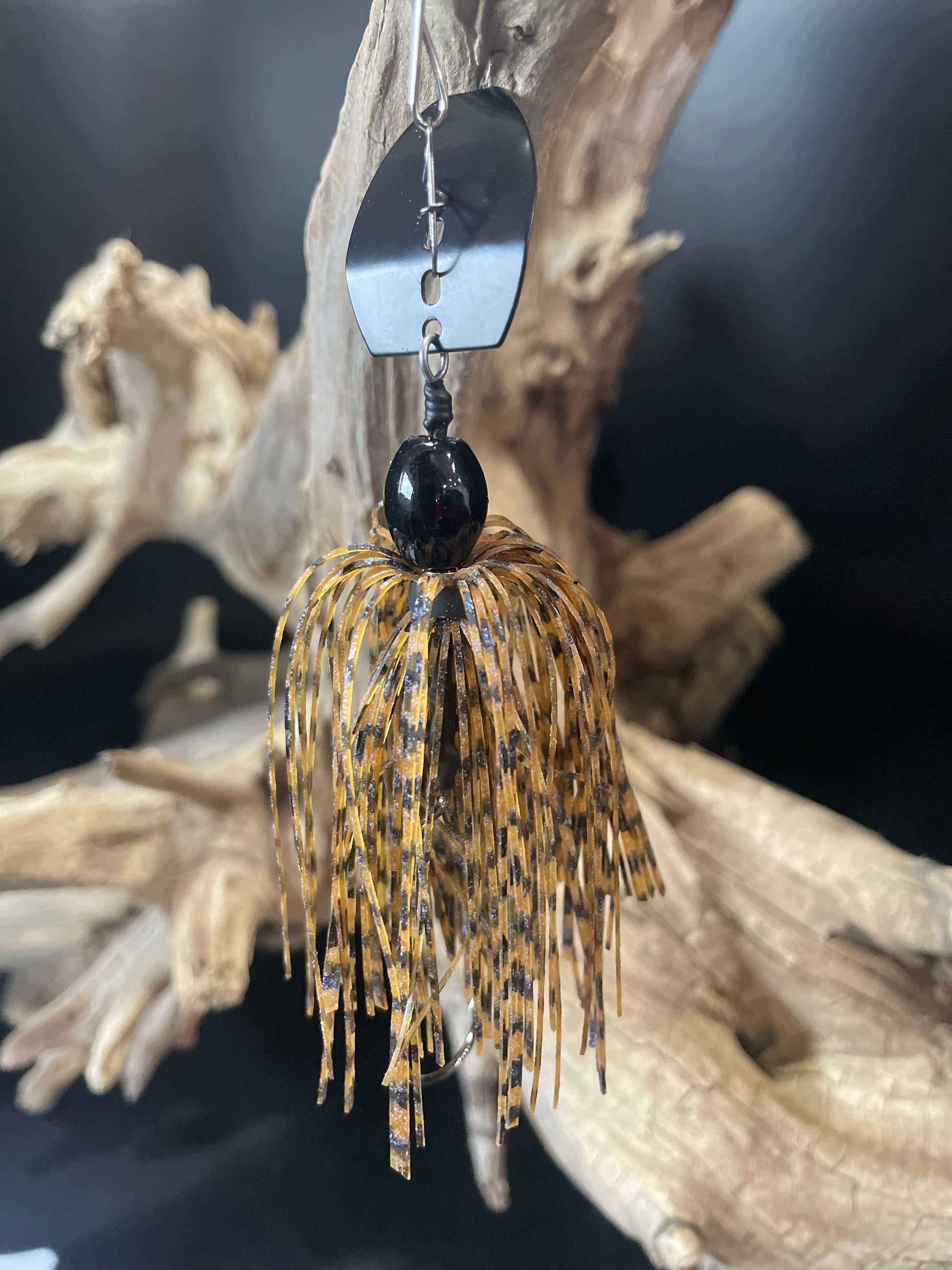 This 3/8 oz bass chatterbait fishing lure features a brown and black colour pattern, along with a #4/0 hook and your choice of a black or silver blade. Its realistic colour and sharp hook provide the perfect bait for catching bass. Upgrade your fishing game now!