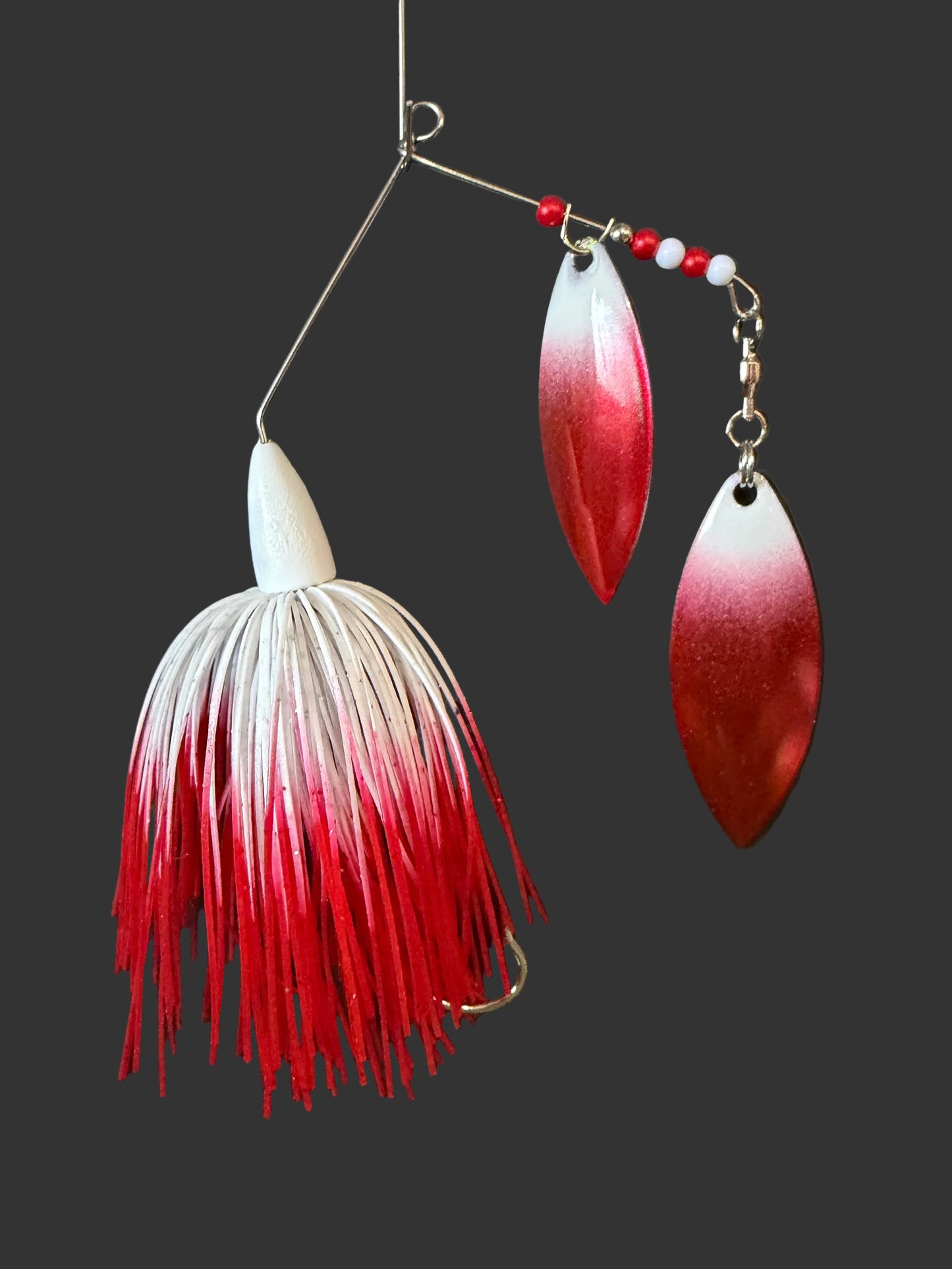 Red & white 3/8 oz spinnerbait with UV glow blades and a #3/0 hook. Built for visibility, strength, and serious strikes. Made to perform in all waters.