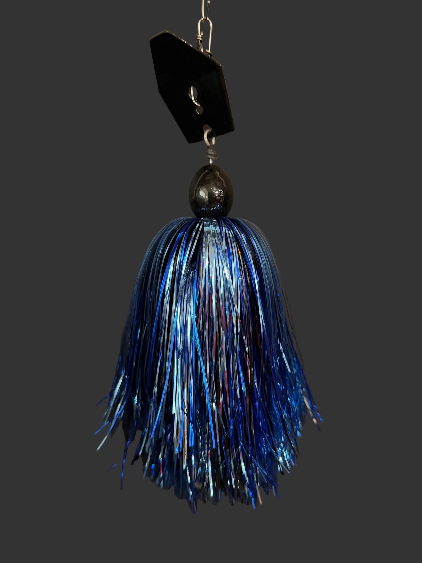 A muskie fishing lure with a black blade and a blue, silver and black skirt. Made by Lure-cifer in Brantford, Ontario Canada
