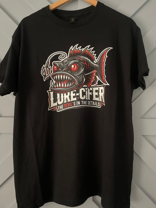 Black Gildan T-shirt branded Lure-cifer with the tag line "the Devil's in the details" picture of a deep sea anglerfish. Lure-cifer Apperal