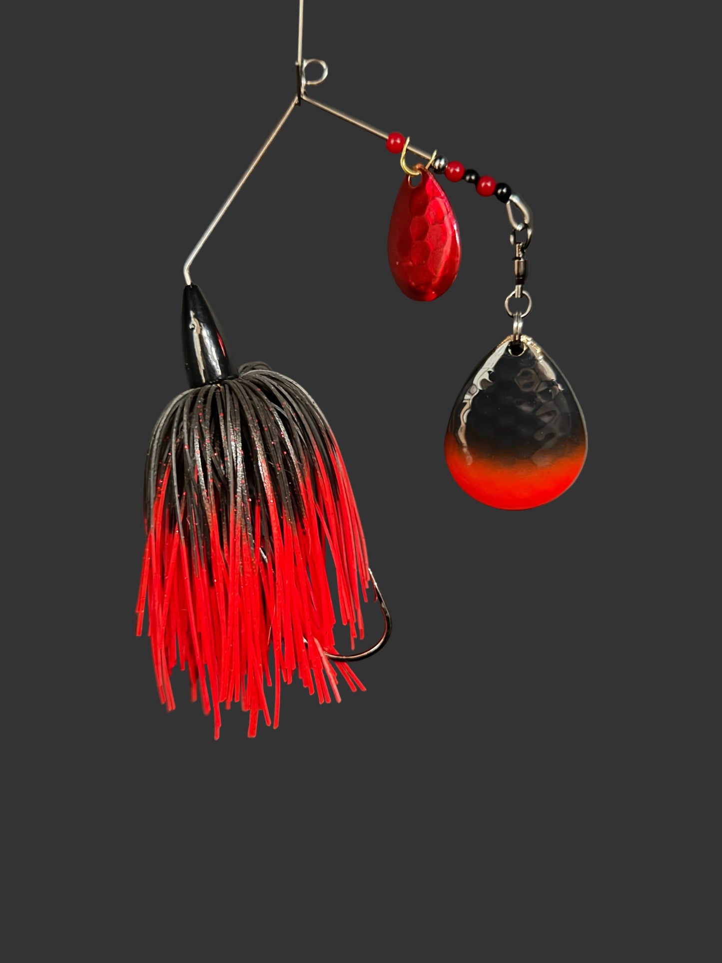 Fishing lure with red and black details on a gray background