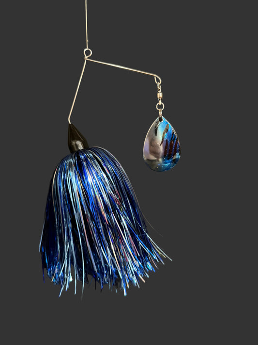 Blue and silver fishing lure on a dark background
