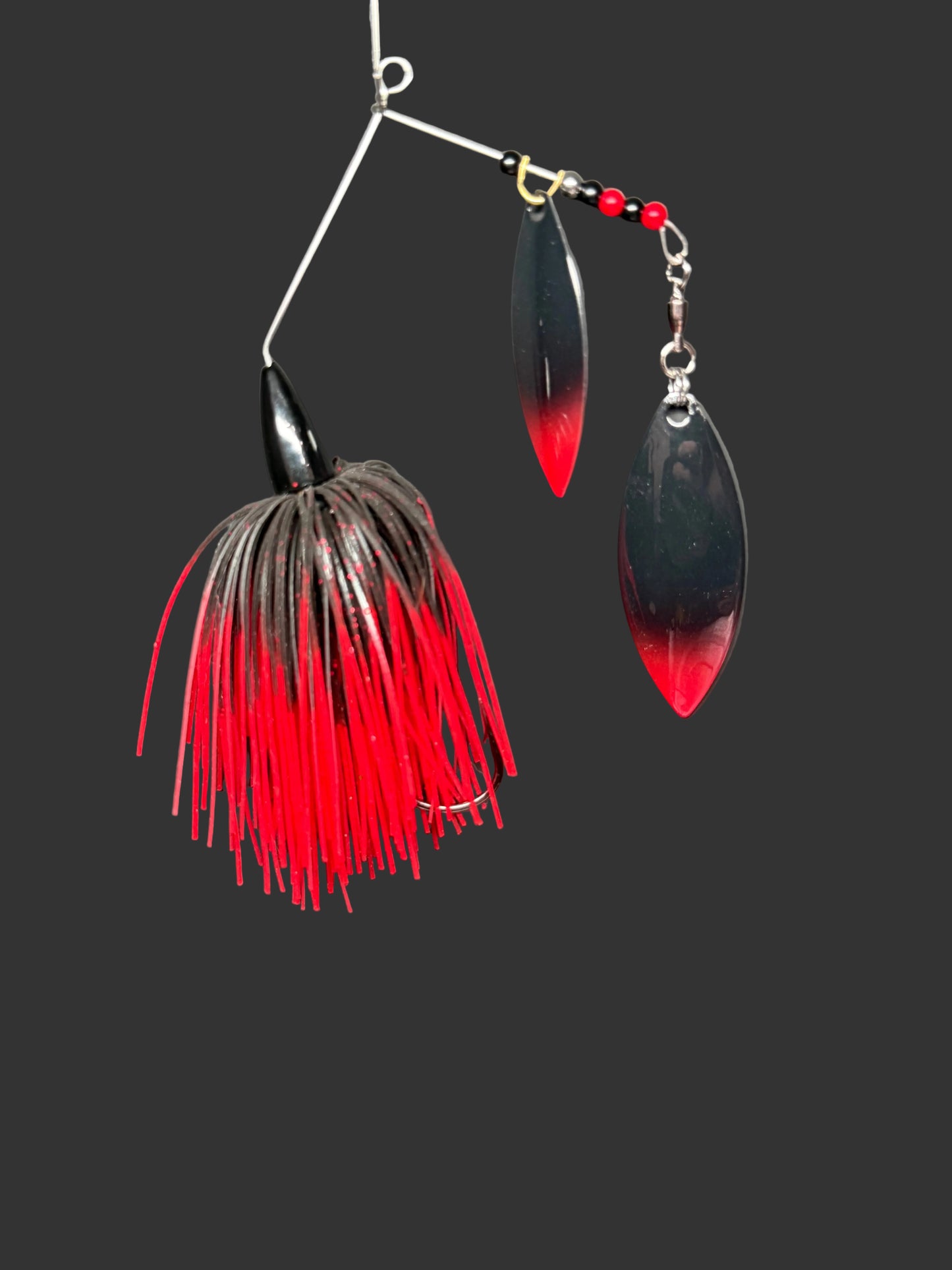 Fishing lure with red and black details on a gray background