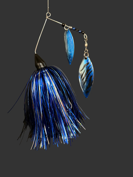 Blue and silver fishing lure on a dark surface