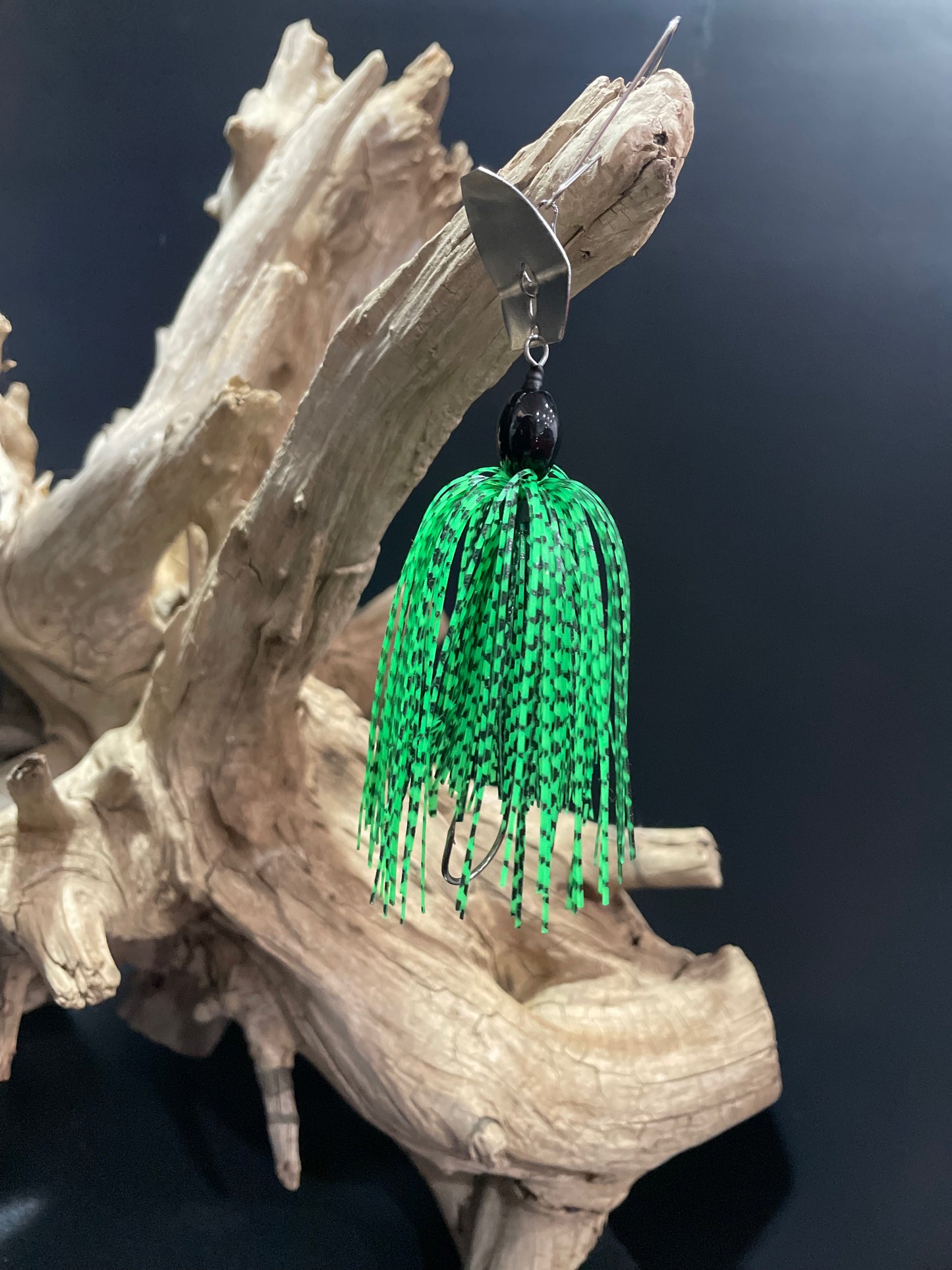 the perfect Chatterbait fishing lure for all your fishing needs! This 3/8 oz Chatterbait features a #3/0  hook and comes with your choice of a black or silver blade. Its unique black and green design is sure to attract all the right bites.