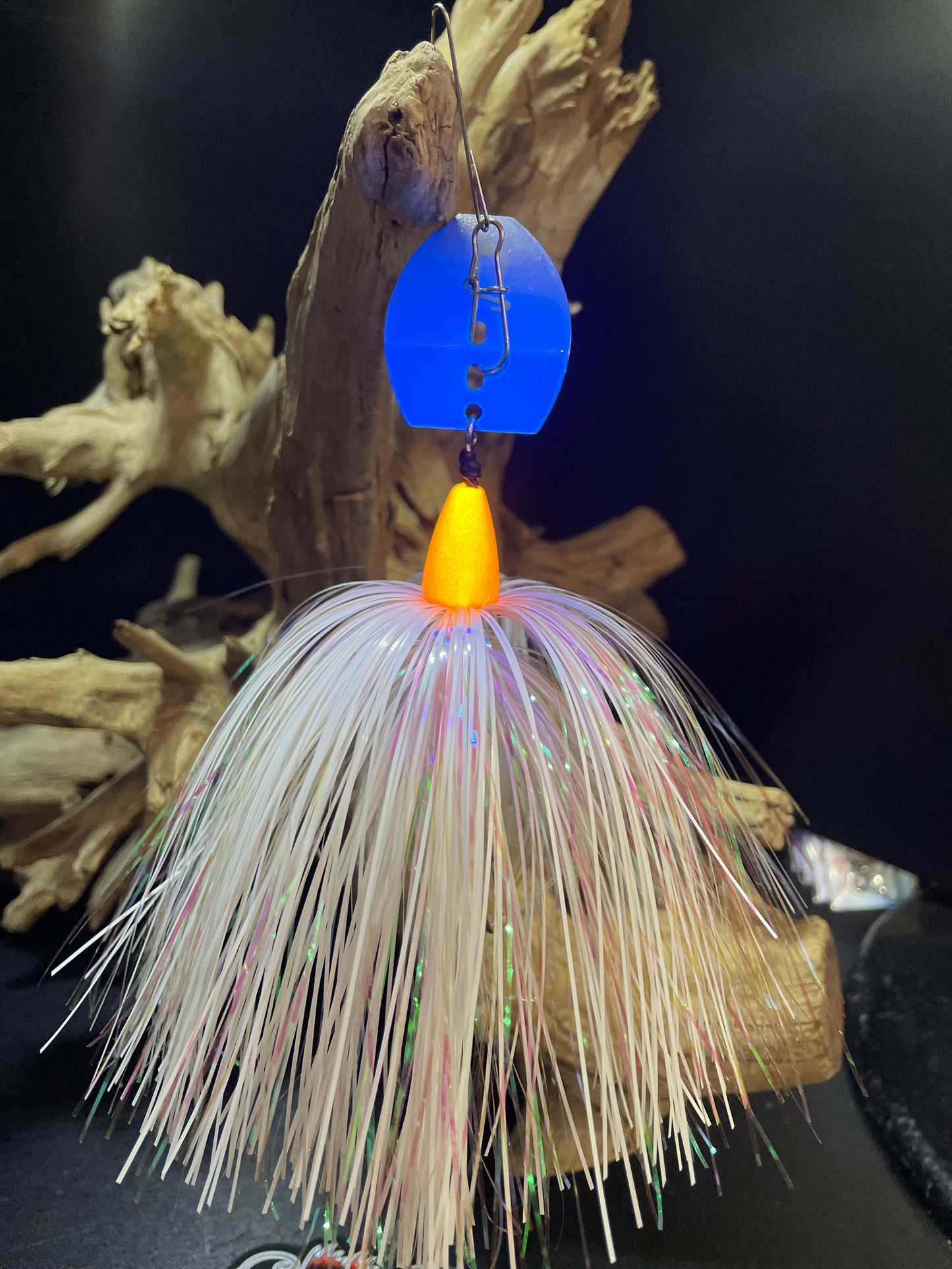 Experience exceptional fishing with Glacier Glow, a 1 oz Chatterbait featuring a white and pearl orange design. The #7/0 hook paired with a glow orange head and UV glow blade guarantees a successful catch. Expertly crafted for maximum performance. Picture of the blade glowing