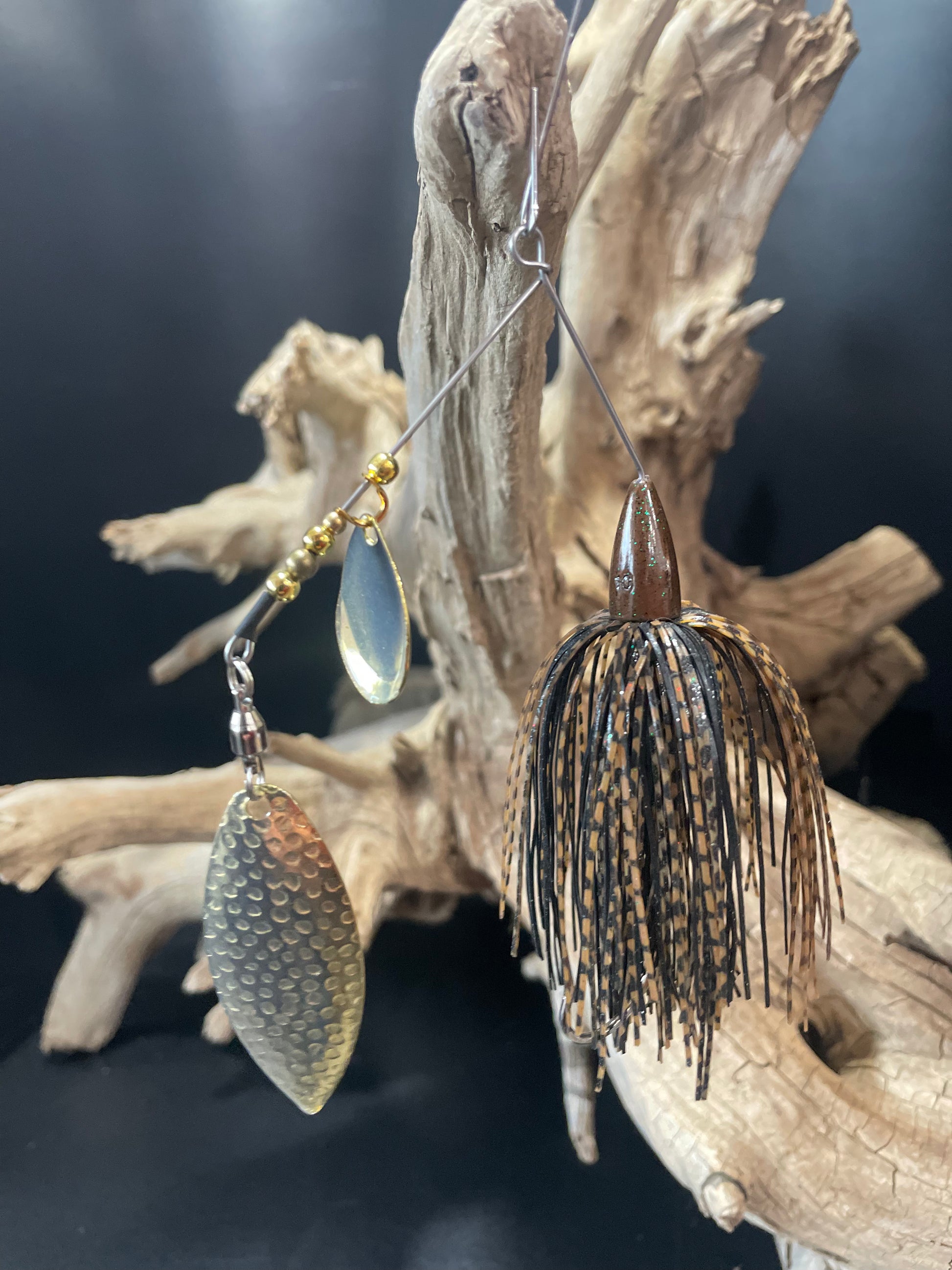 A black and brown Bass designed spinnerbait fishing lure, weighing 3/8 oz. Equipped with a #5 Willow blade and #4/0 hook, it's sure to attract a wide range of fish. Don't miss out on this must-have addition to your fishing gear.