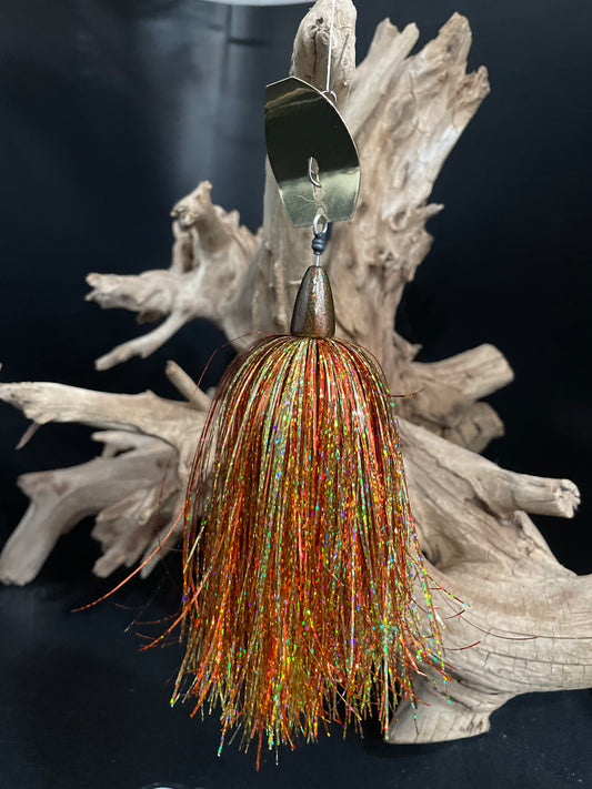 Fishing lure with multicolored tinsel on a wooden stand against a dark background