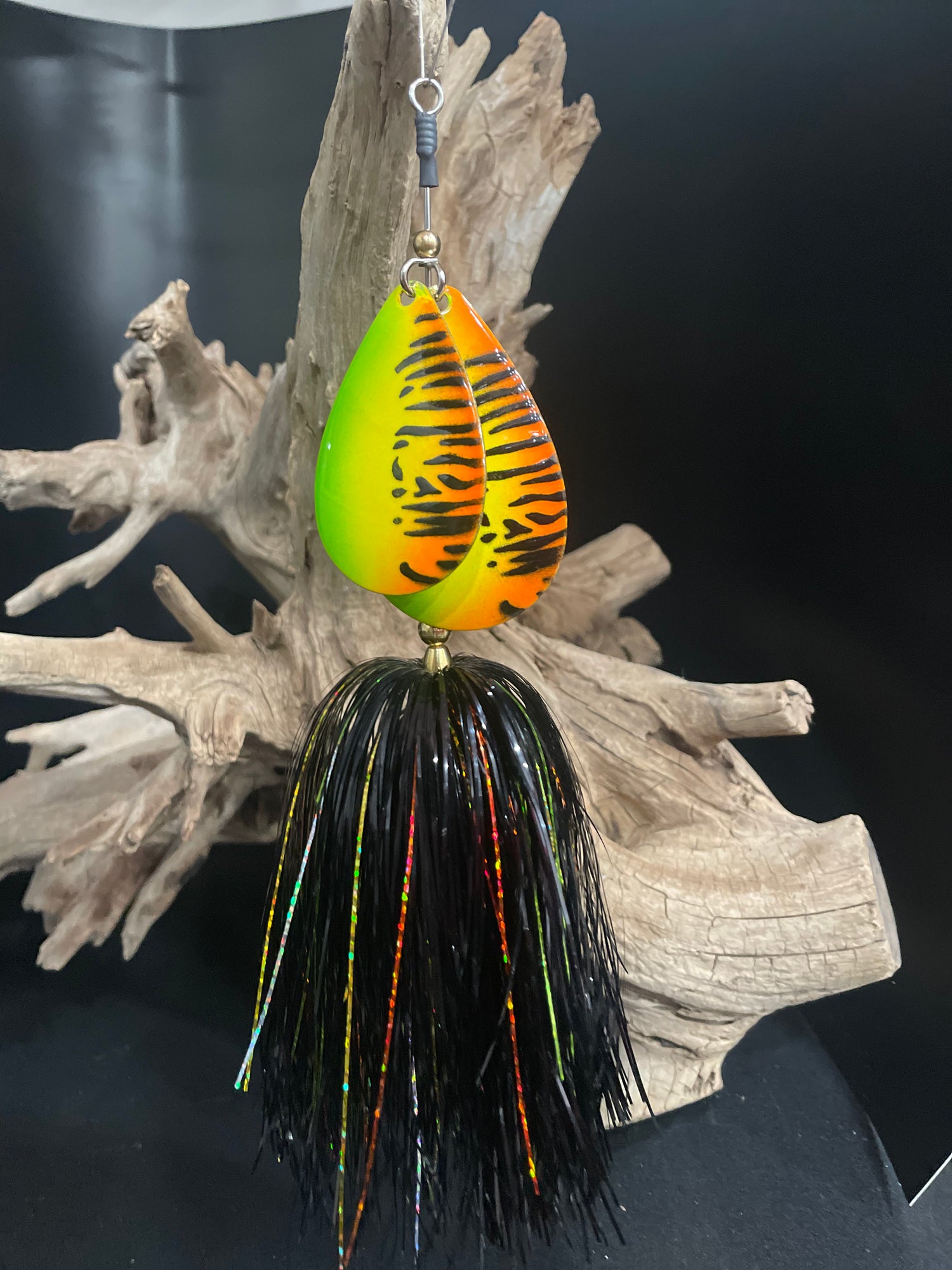 Fishing lure with tiger stripe pattern on a black background