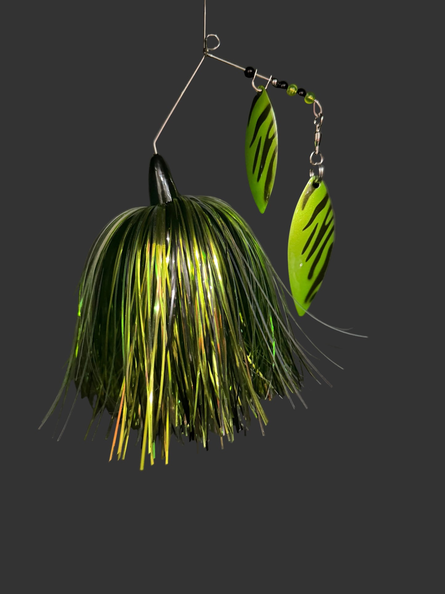 Fishing lure with green and gold details on a dark background