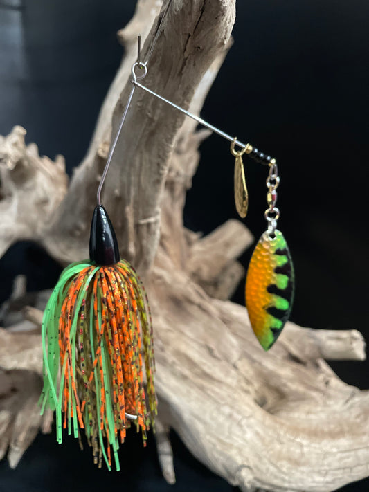 Green, orange & brown 3/8oz spinnerbait. Wired skirt and a #3/0 hook with snap ring. Built for visibility, strength, and serious strikes. Made to perform in all waters.