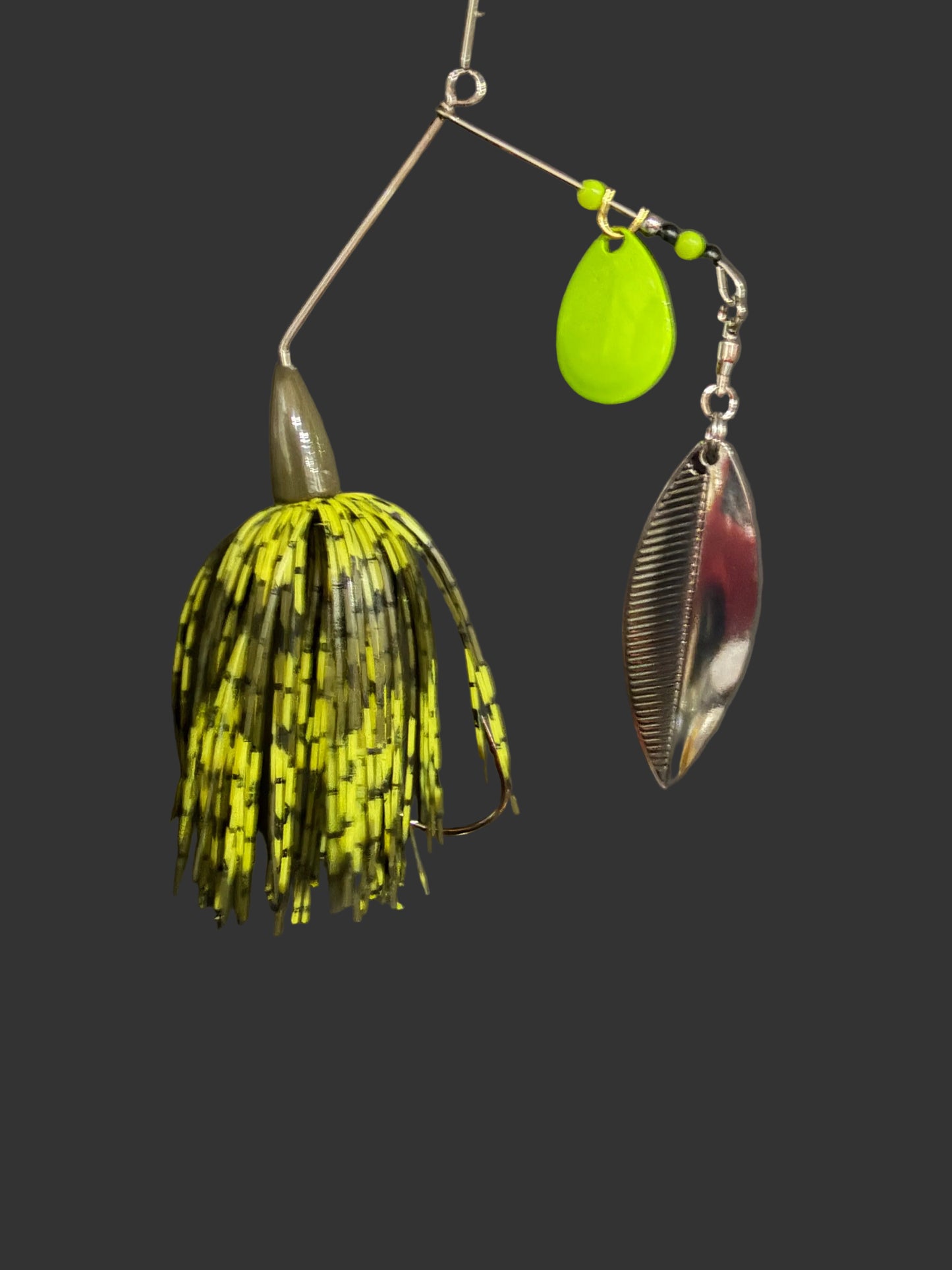 3/8oz bass Spinnerbait with an olive green and chartreuse skirt and dual blades, one chartreuse and one silver, on a dark grey background