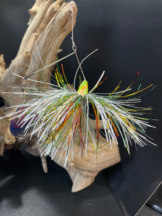 Nuclear Sunrise is a bass spinnerbait fishing lure with a #7 Colorado UV Glow blade and a #5/0 hook. Its white, yellow, green, and orange colour scheme is designed to attract fish in all conditions. Available in both 1/2 oz and 3/4 oz sizes, it's a must-have for any serious angler.