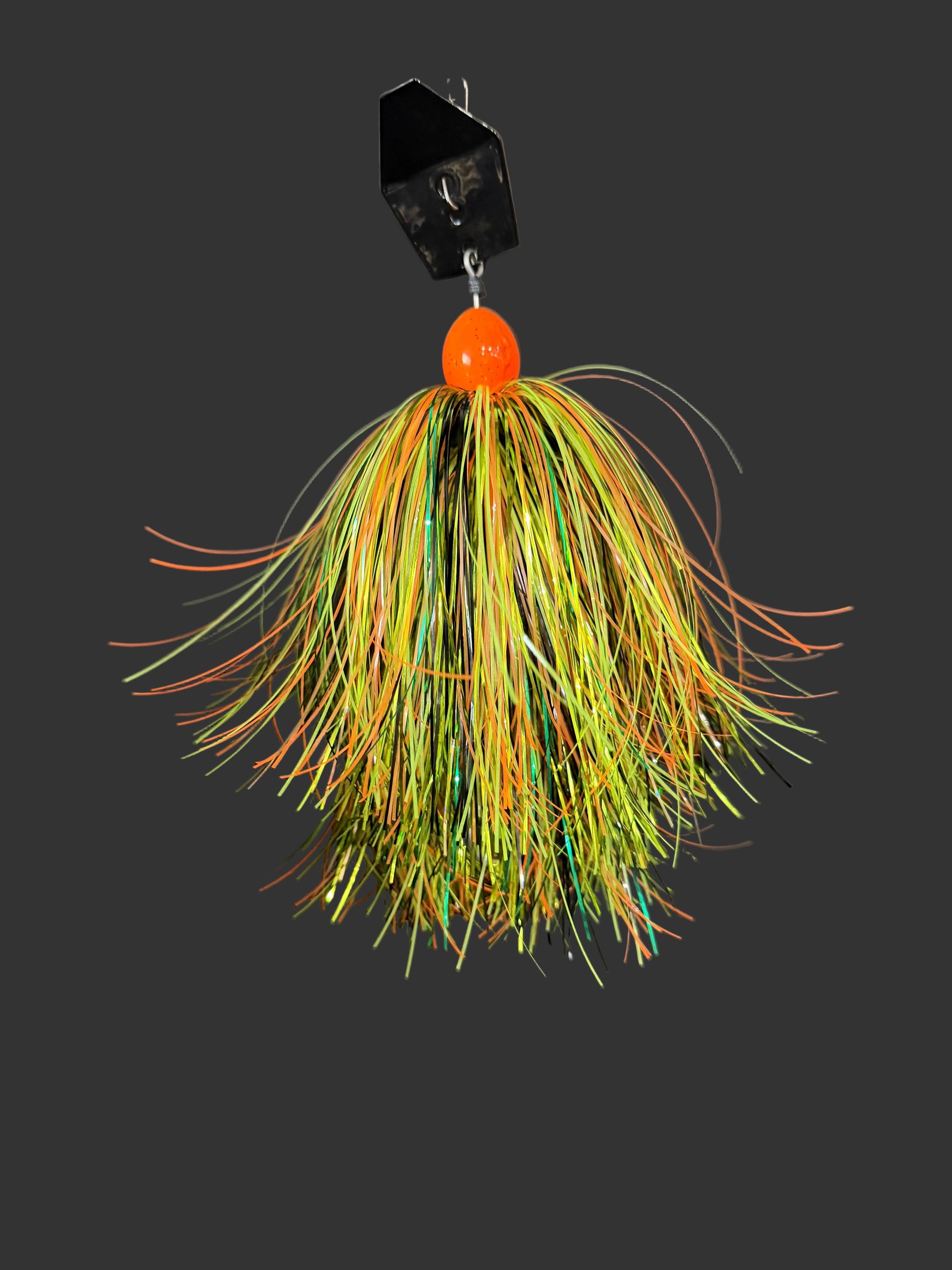 A Muskie chatterbait with an orange weight and a yellow, orange and green skirt and black blade. Made by Lure-cifer