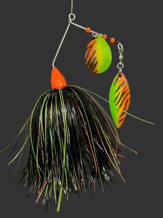 Fishing lure with green and orange blades on a dark background