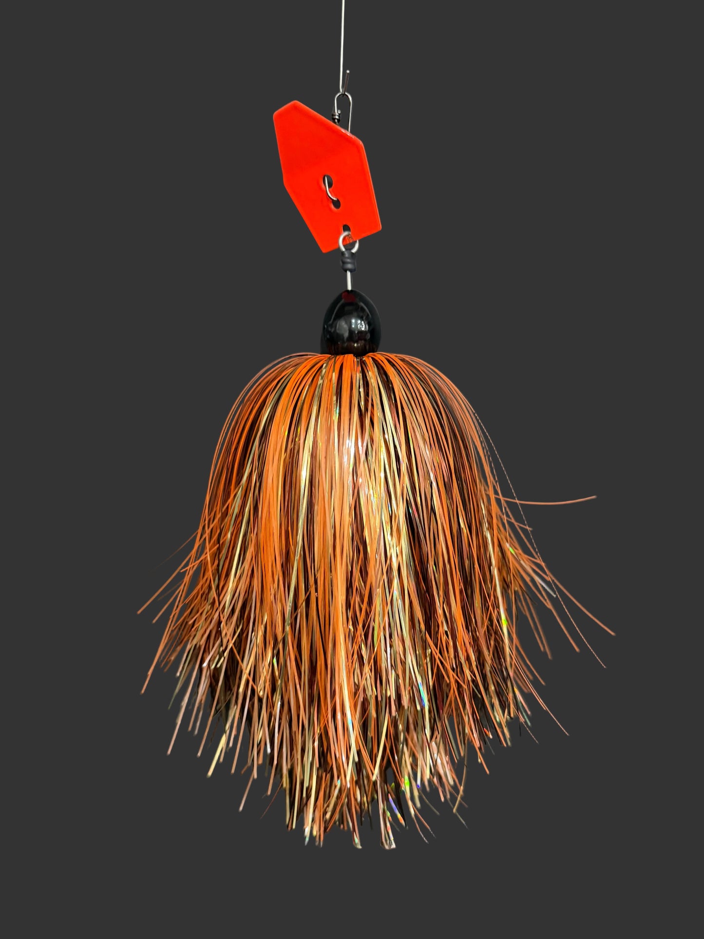A Muskie fishing lure with an orange blade and a orange, gold, and bronze skirt. 