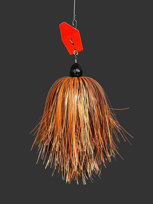 A Muskie fishing lure with an orange blade and a orange, gold, and bronze skirt. 