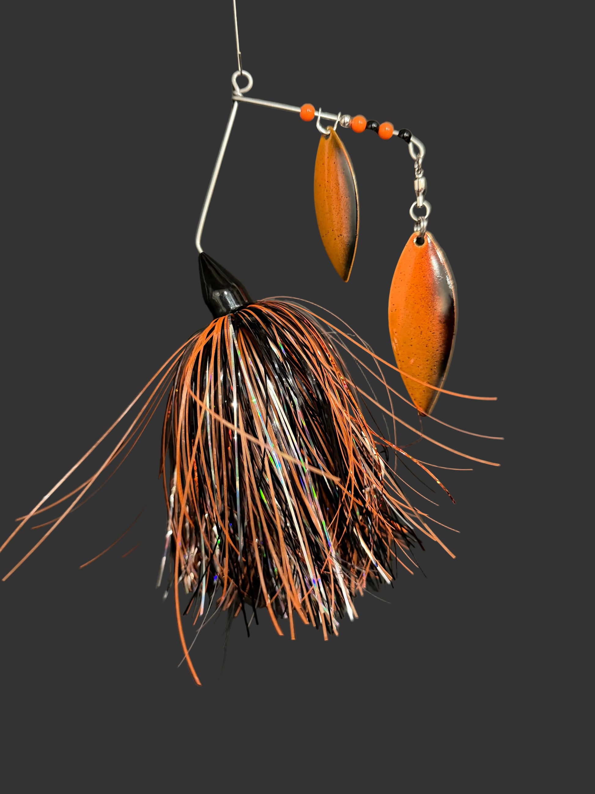 Muskie/Pike Fishing Lure with a black and orange skirt and blade on a grey background. Made by Lure-cifer in Brantford Ontario Canada