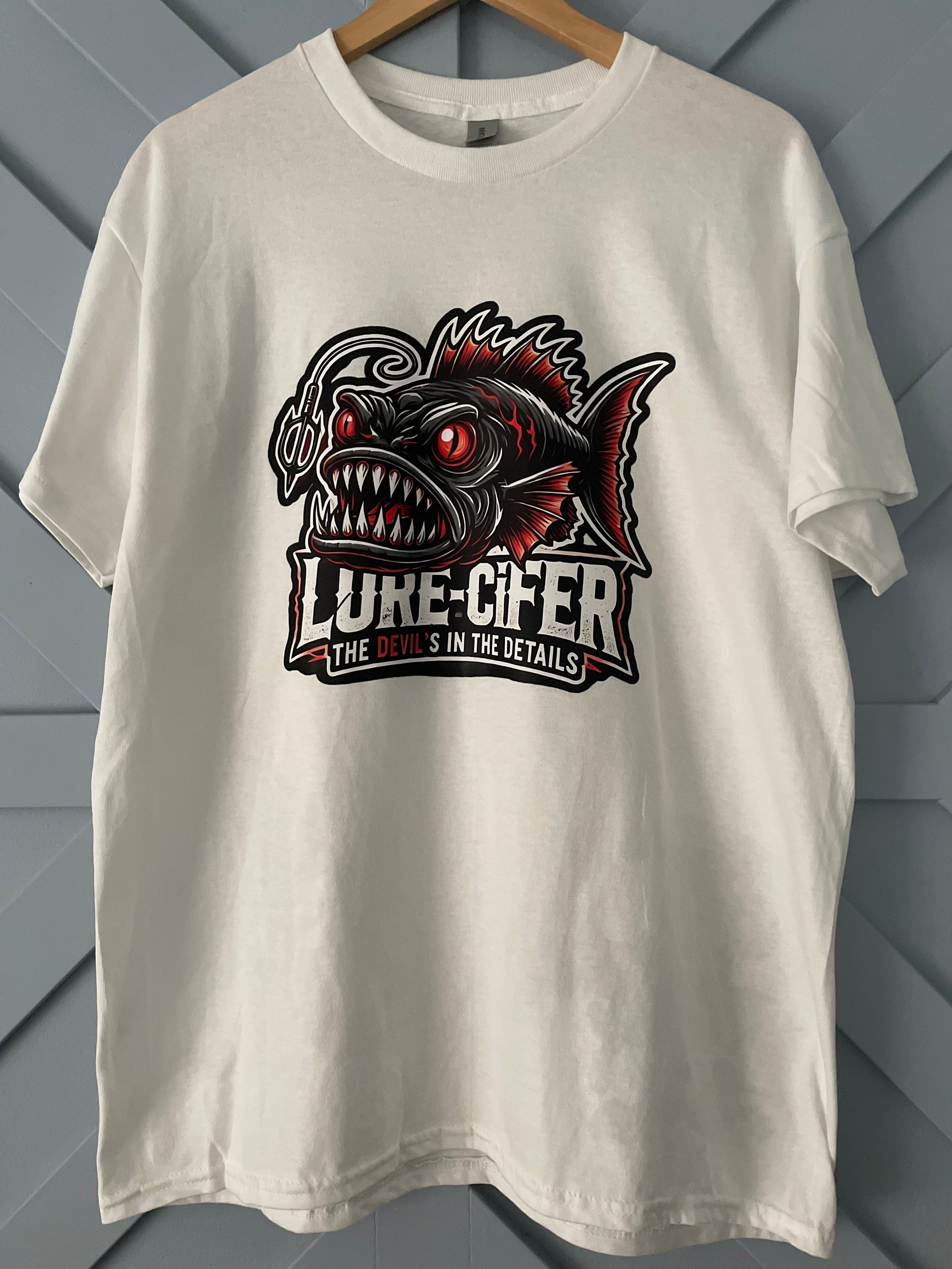 white Gildan T-shirt branded Lure-cifer with the tag line "the Devil's in the details" picture of a deep sea anglerfish
