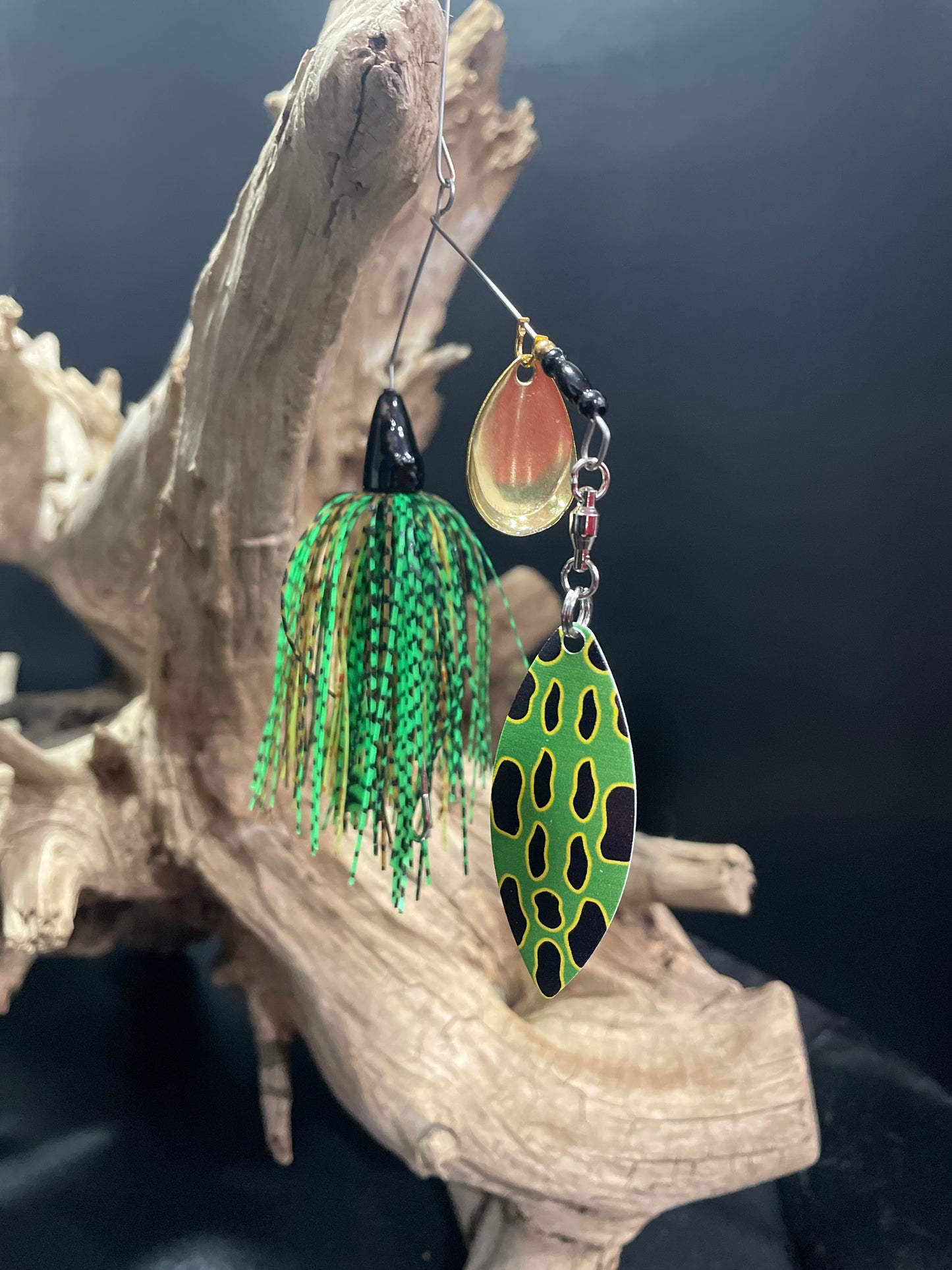 A 3/8 oz Bass Spinnerbait fishing lure featuring a #4/0 hook, #5 Willow Blade, and deep cut Colorado blade. Catch more fish with this green and black lure designed for optimal performance.