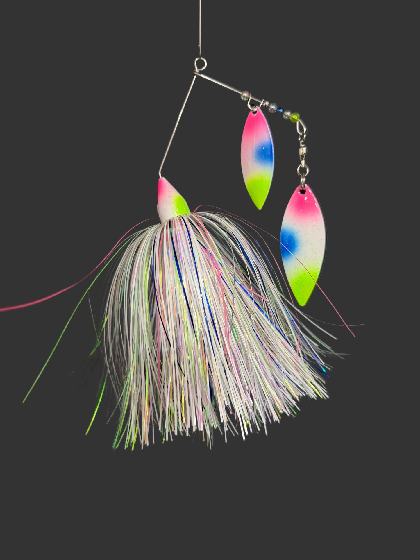 Fishing lure with colorful blades and feathered body on a black background