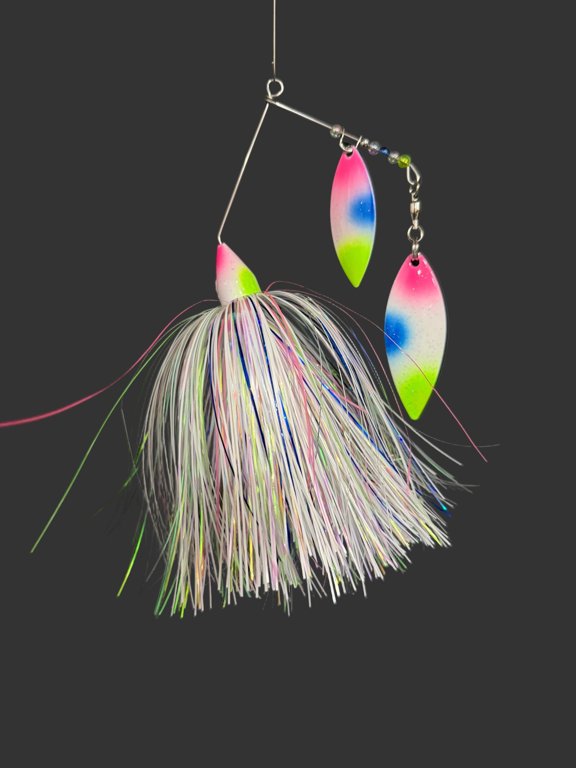 Fishing lure with colorful blades and feathered body on a black background